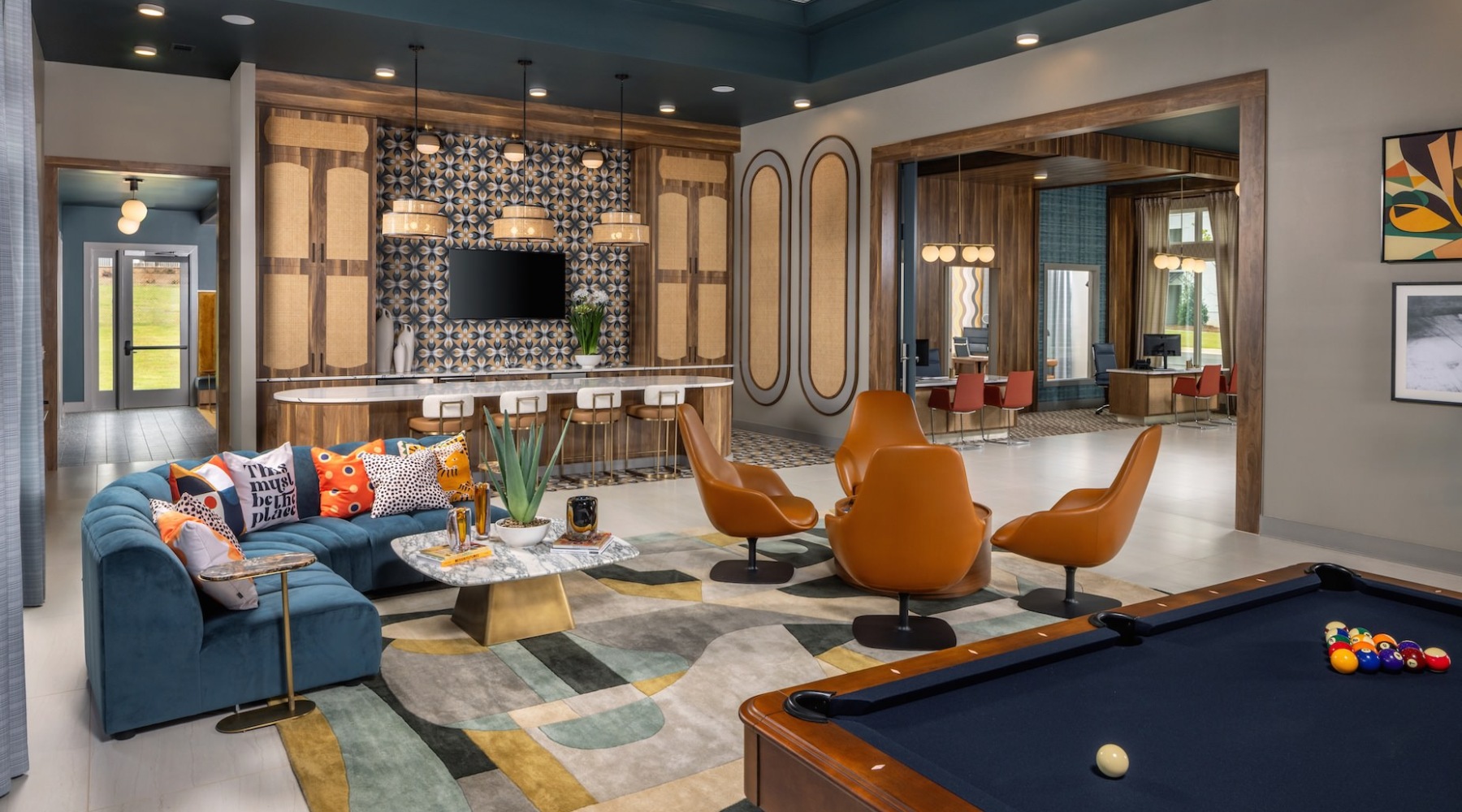 Mid century style community lounge area with seating and neon sign at The Weldon by Broadstone apartments in McDonough, GA